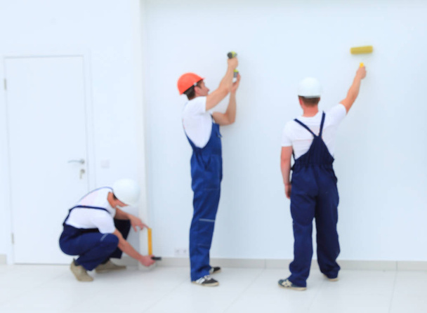 team of builders finishers work indoors - Foto, Imagem