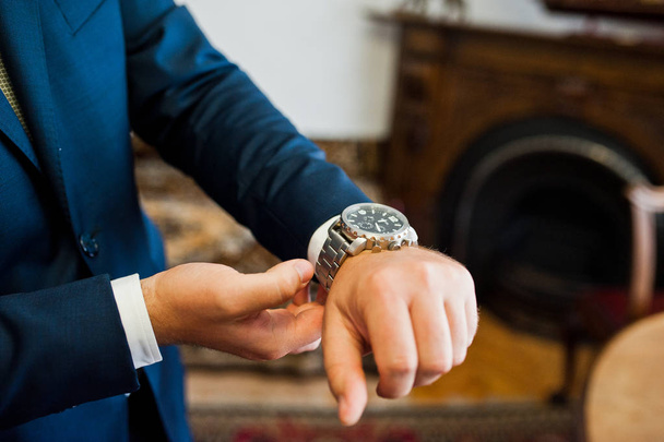 Close-up photo of a groom putting on a golden watch on his wrist - Photo, Image