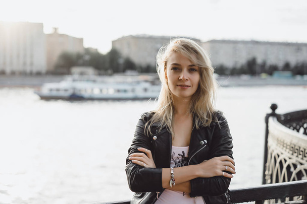 young blonde woman in black jacket outdoor - Fotoğraf, Görsel