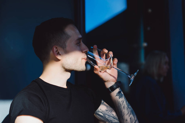 Tattooed man drinking wine - Фото, зображення