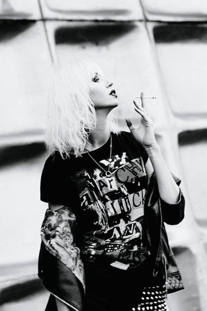 Monochromes Porträt einer stilvollen blonden Grunge-jungen Frau beim Zigarettenrauchen - Foto, Bild