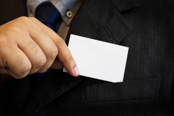 business man showing business card. Black suit and tie. - Zdjęcie, obraz