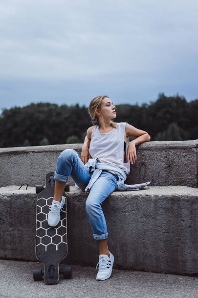 Girl sitting with longboard - Zdjęcie, obraz