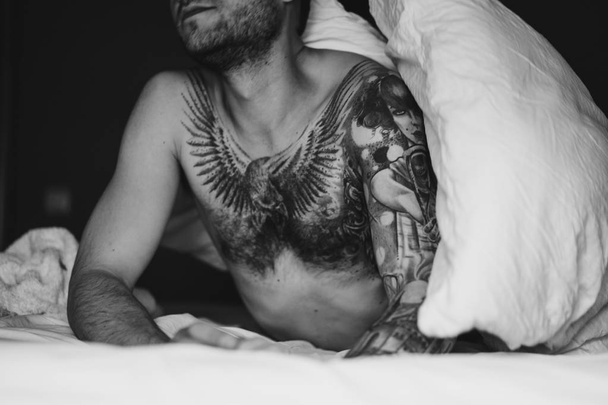 Tattooed man in bed - Foto, Imagem