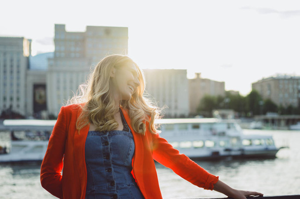 young blonde woman in red jacket outdoor - Foto, Imagen