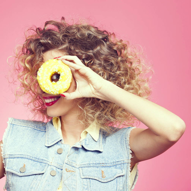 young woman  looking through donut - Foto, imagen