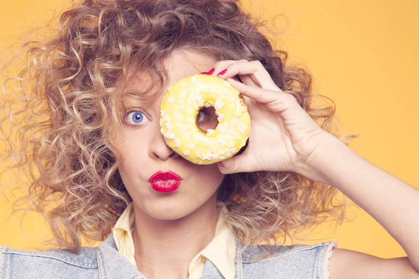 young woman  looking through donut - Photo, image