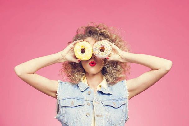 young woman holding donuts - Foto, afbeelding