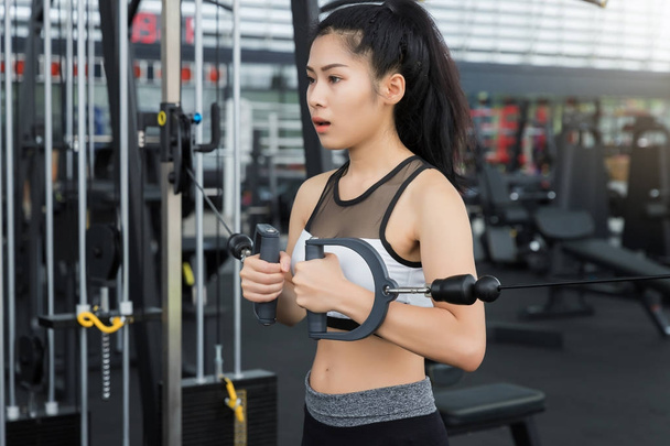 Closeup of a young fitness asian woman workout at sport club. - Valokuva, kuva