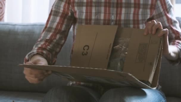 STRASBOURG, FRANCE - CIRCA 2017: Woman unpacking or unboxing Amazon Prime cardboard box at home delivery opening cardboard and parcel Meguiars Perfect Clarity Glass Cleaner - Materiaali, video