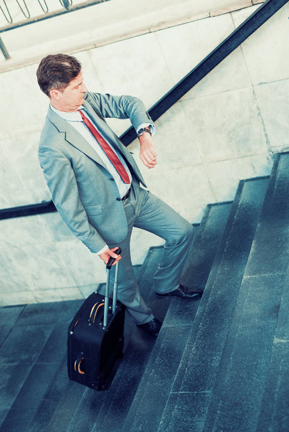 Businessman going up with suitcase. - Zdjęcie, obraz