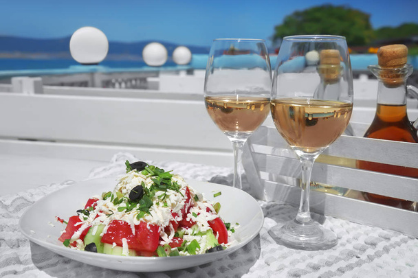 Two glasses of white wine and plate with exotic salad - Photo, image