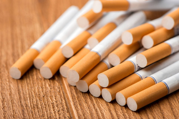 sigaret, sigaret op een houten achtergrond, sigaretten op een tafel, close-up van een sigaret - Foto, afbeelding