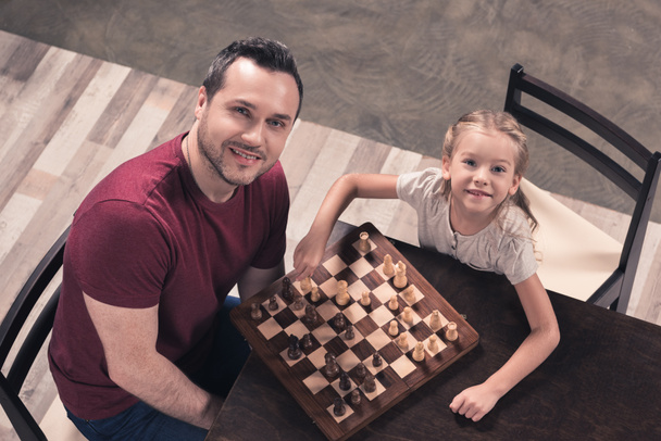 Ojciec i córka pozowanie z szachownicy - Zdjęcie, obraz