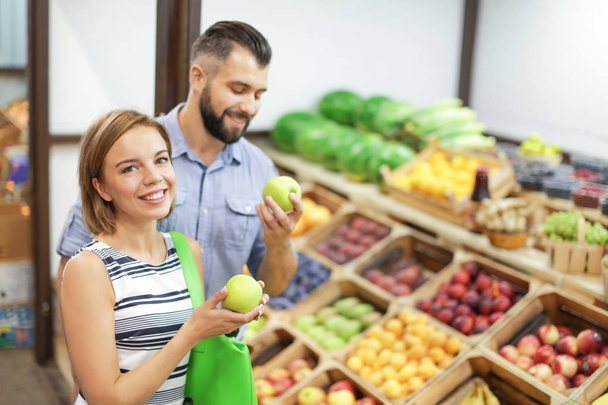 Young couple choosing fruits at market - Zdjęcie, obraz