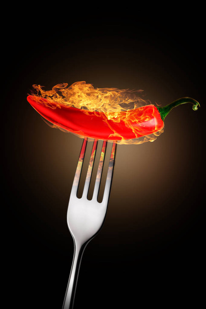 Mexican red pepper on a fork with a flame - Photo, Image