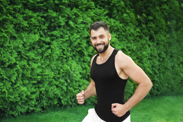 Sporty man running outdoors - Photo, Image
