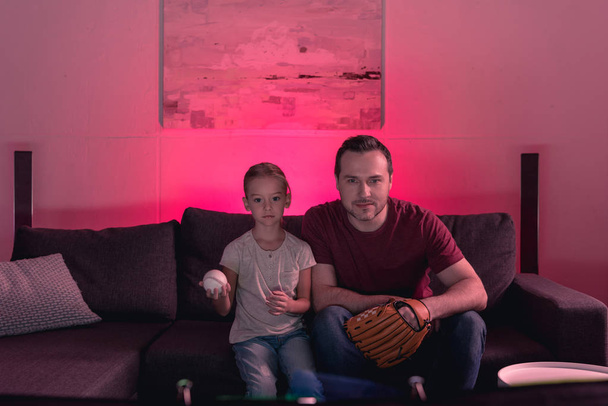 Батько і дочка дивиться гру в бейсбол
 - Фото, зображення