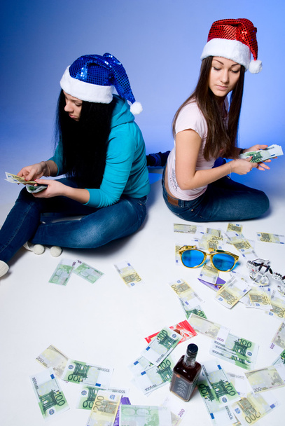 Two girls in Santa hats believe banknotes - Fotoğraf, Görsel