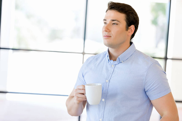 Young businessman in office with a mug - Foto, Imagem