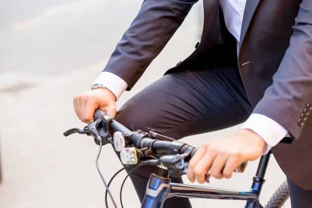 Successful businessman riding bicycle - Фото, изображение