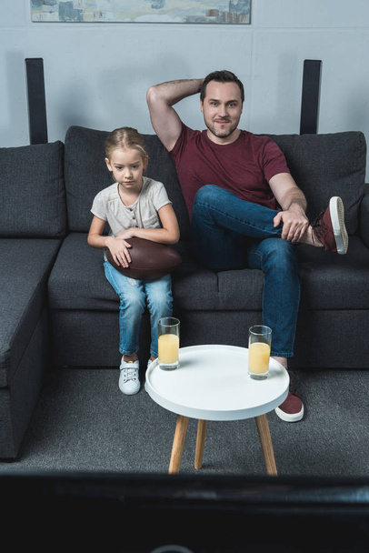 Father and daughter watching american football game - Fotoğraf, Görsel
