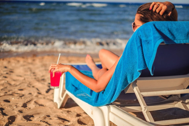 Дівчина насолоджується коктейлем на пляжі
 - Фото, зображення