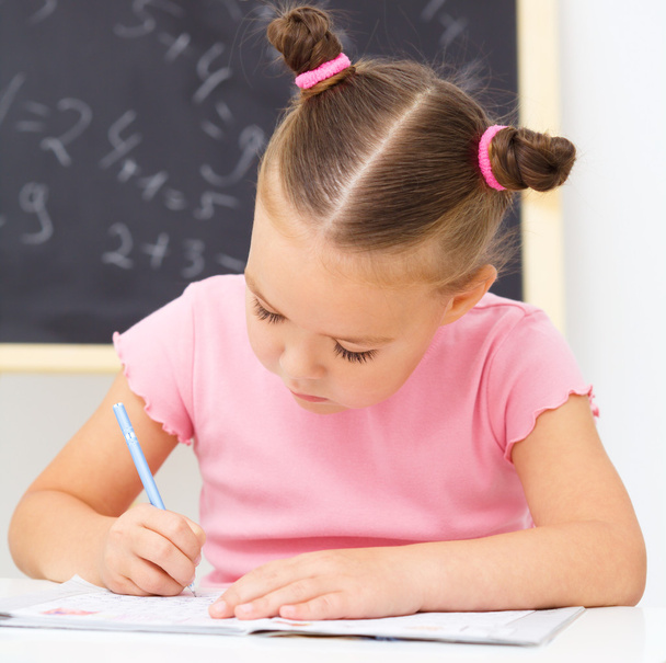 Маленька дівчинка пише ручкою
 - Фото, зображення