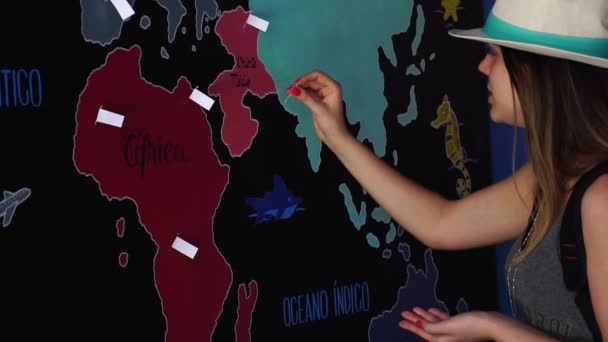 Traveler Woman Putting Pin Ubicación de los Países Viajados El Mapa
 - Imágenes, Vídeo