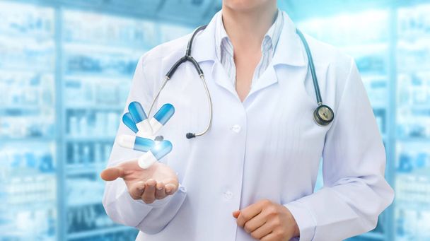 Pharmacist in hand showing pills on the background . - Photo, Image