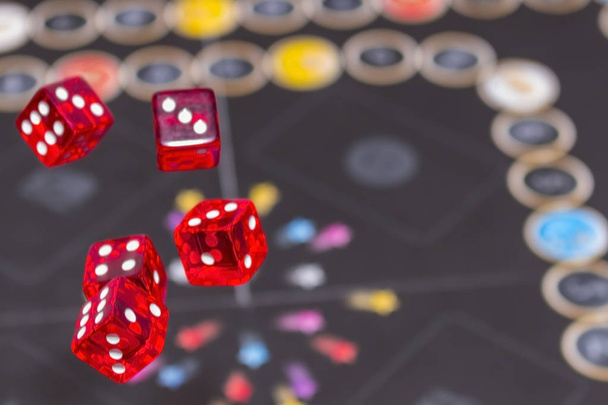 A sötét háttér, a koncepció a kockázat, a szerencsejáték és a véletlen piros kocka. - Fotó, kép