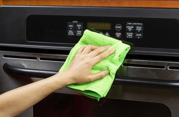 Reinigung von Küchengeräten und Entlüftungsöffnungen am Elektroherd - Foto, Bild