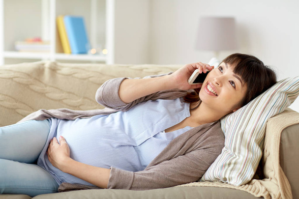 heureuse femme enceinte appelant sur smartphone à la maison - Photo, image