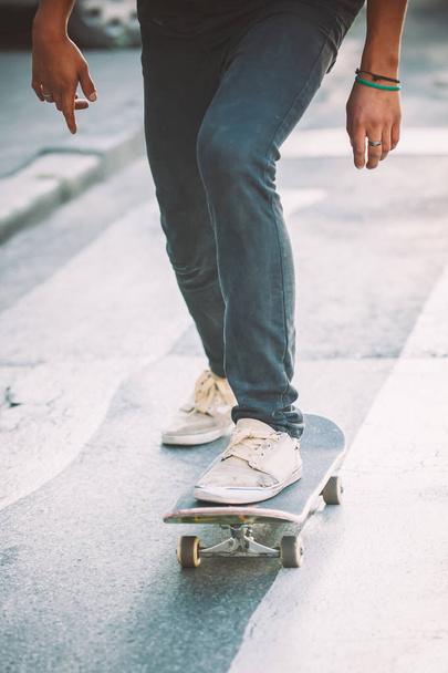 Skateboarder legs riding skateboard on the street - Foto, Imagem
