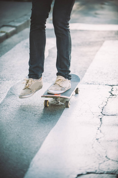 Skateboarder legs riding skateboard on the street - Фото, зображення