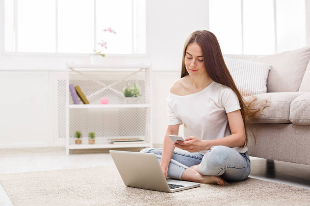 Young happy woman with laptop and smartphone - Photo, Image
