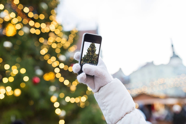 hands with smartphone photographing christmas tree - 写真・画像