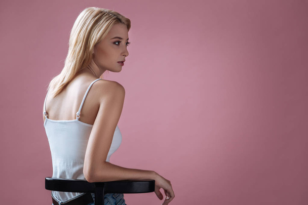 Beautiful girl leaning on black support - 写真・画像