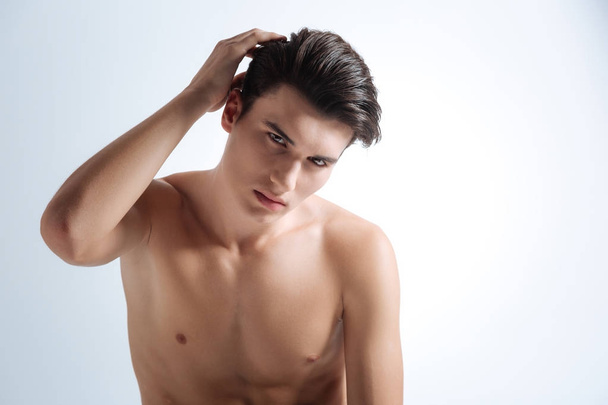 Attractive model smoothing his hair - Φωτογραφία, εικόνα
