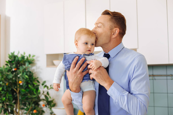 Delighted loving man kissing his baby daughter - Zdjęcie, obraz
