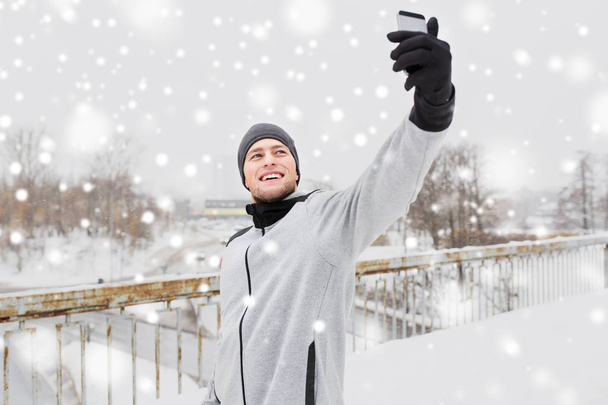 man taking selfie with smartphone in winter - Fotoğraf, Görsel