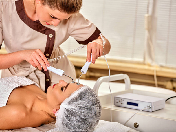 Facial massage at beauty salon. Electric stimulation woman skin care. - Photo, Image