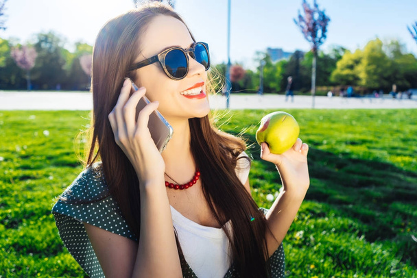 Woman smiling while phone talking on diet outside - Foto, Bild