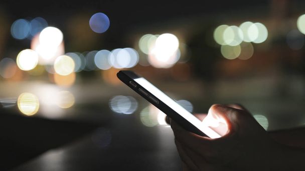Woman using mobile phone at night - Foto, Bild