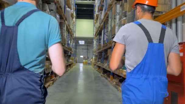 A view on warehouse workers going away. - Video