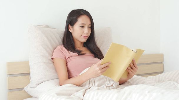 Woman reading book on bed  - Φωτογραφία, εικόνα