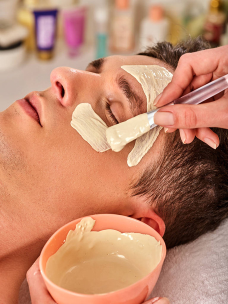 Mud facial healing mask of man in spa salon. - Photo, Image