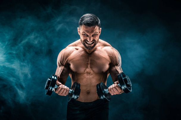 Muscular man with dumbbells - Φωτογραφία, εικόνα