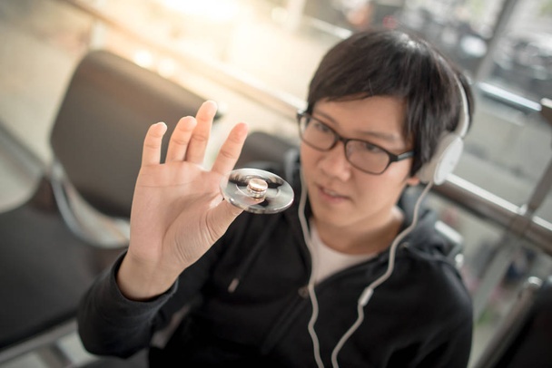 Young asian man playing spinner fidget in airport - Foto, Imagem