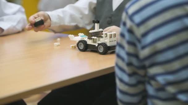 Childrens hands collect a car from designer - Filmati, video